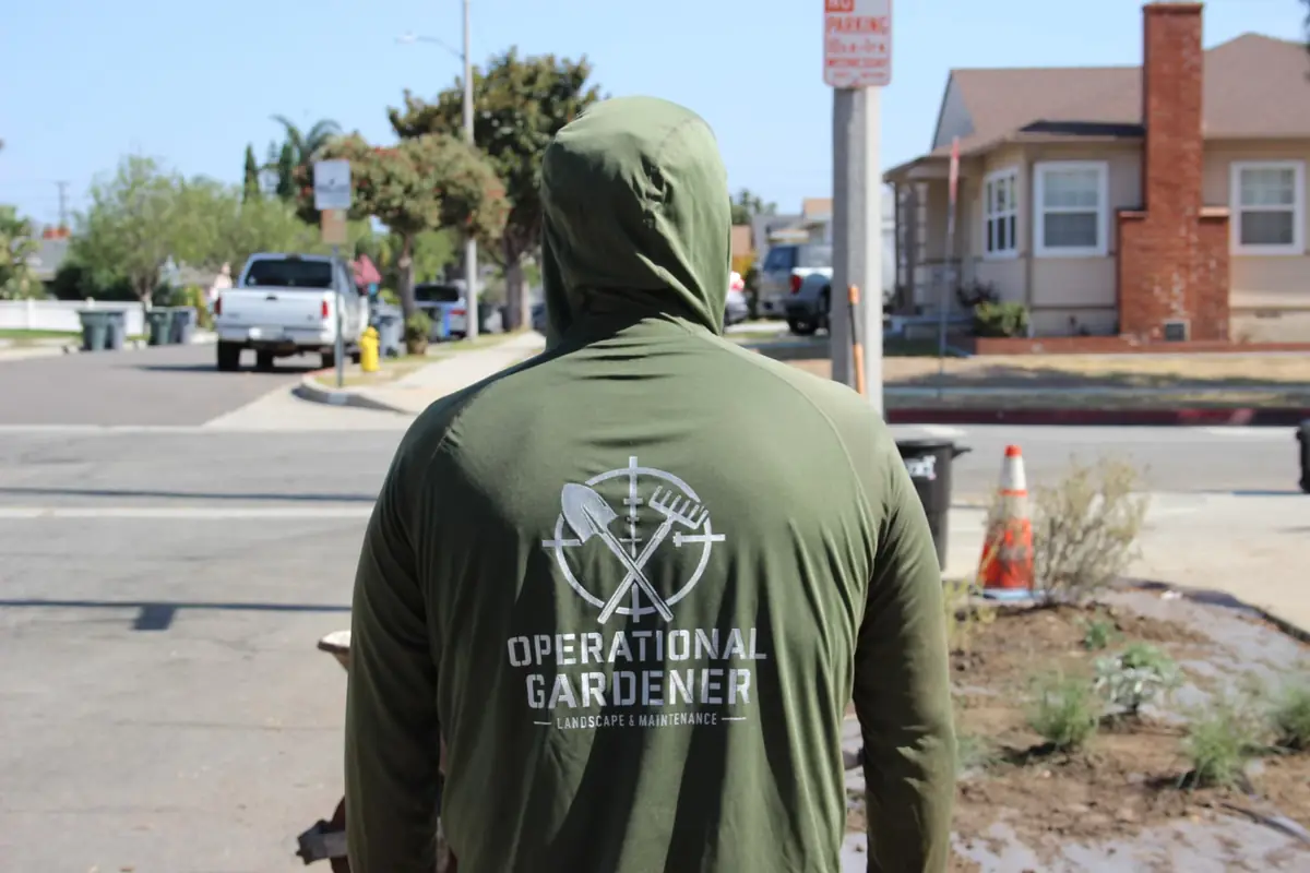 Operational Gardener team member wearing branded company shirt at a landscape project in Southern California