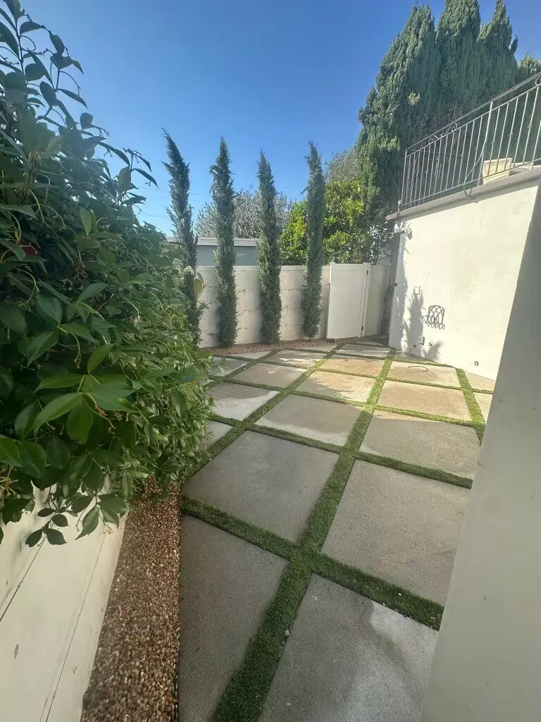 Side yard grid-set pavers with turf joints and Italian cypress in Torrance, California